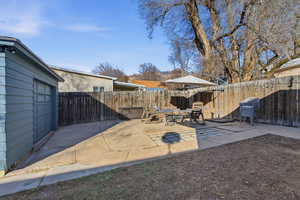 Fenced backyard featuring a patio area and an outdoor fire pit