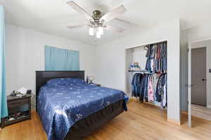 Bedroom with a closet, light wood-type flooring, and a ceiling fan