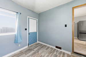 Foyer entrance with light wood-style floors and a textured ceiling
