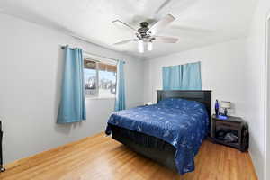 Bedroom with a ceiling fan and wood finished floors