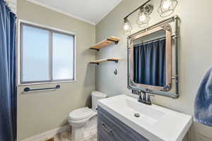 Full bath with a shower with shower curtain, crown molding, vanity, and wood finished floors