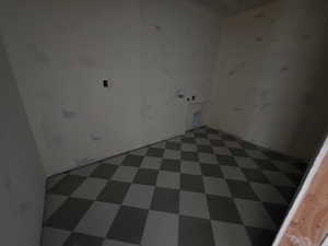 Washroom featuring dark flooring and electric dryer hookup