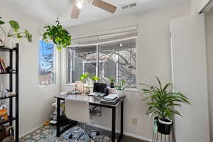 Home office featuring ceiling fan and carpet