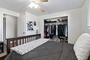 Bedroom with a closet, ceiling fan, and carpet flooring