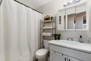 Full bathroom with curtained shower and vanity