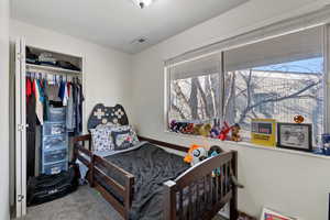 Carpeted bedroom featuring a closet and a textured ceiling