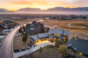 Aerial perspective of suburban area featuring a mountain backdrop and a local golf course