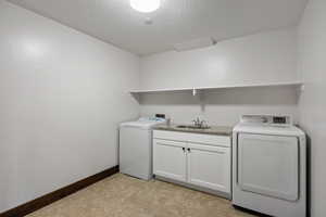 Washroom featuring a textured ceiling, washer hookup, and cabinet space