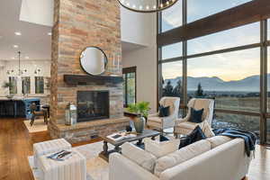 Living area featuring hardwood / wood-style flooring, a mountain view, a fireplace, a chandelier, and a towering ceiling