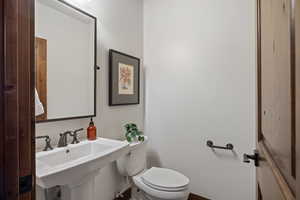 Half bath featuring toilet and a sink