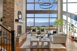 Living room with a fireplace, a high ceiling, dark wood finished floors, a mountain view, and stairs