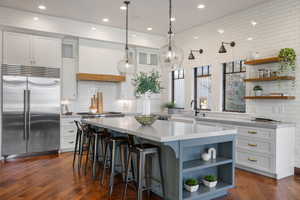 Kitchen with open shelves, built in fridge, white cabinetry, and recessed lighting