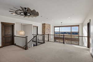 Corridor with an upstairs landing, carpet, a textured ceiling, and recessed lighting