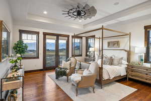 Bedroom featuring dark wood-style floors, ceiling fan, access to exterior, a tray ceiling, and recessed lighting