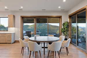 Dining room with light wood-style flooring, a mountain view, and recessed lighting