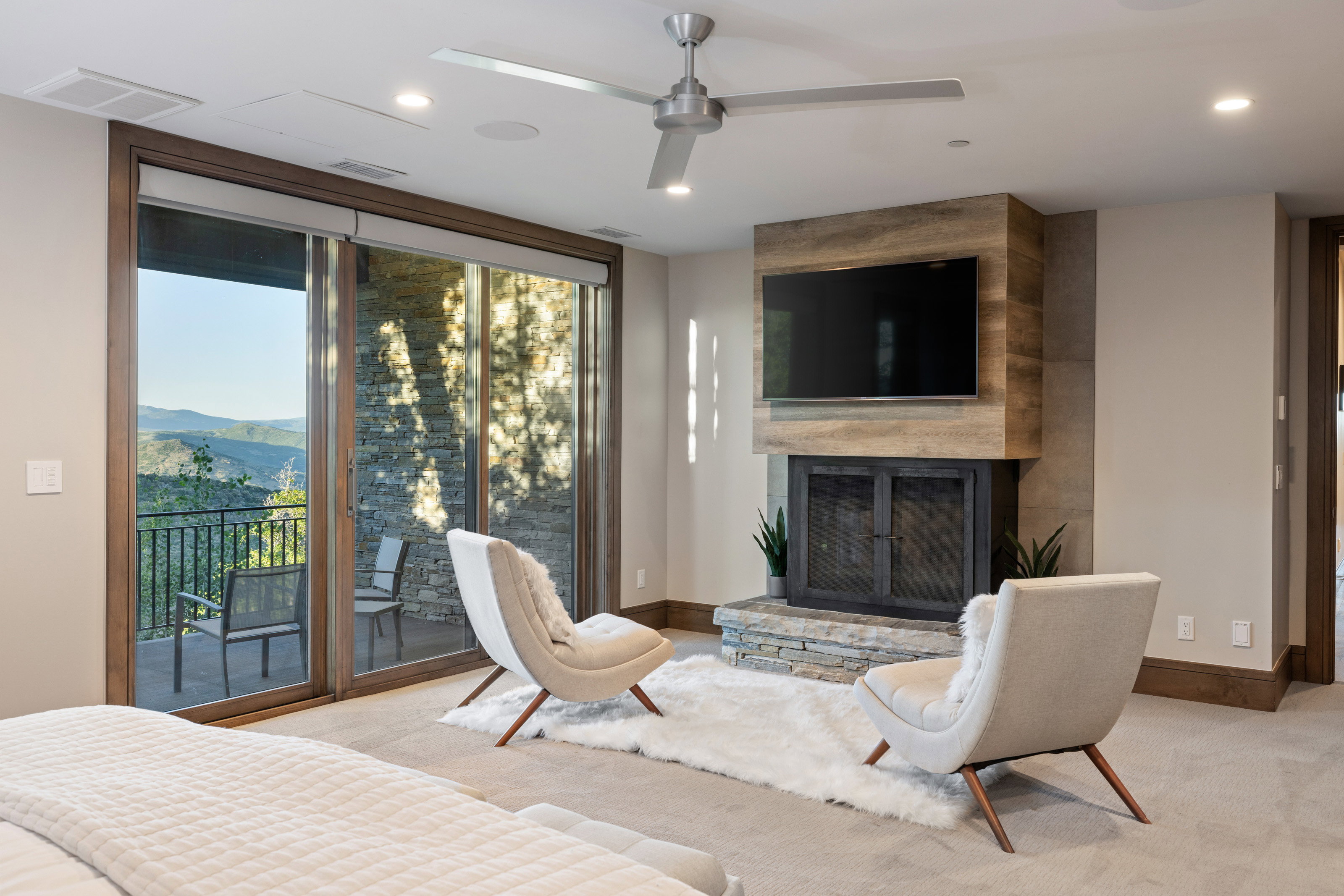 Carpeted living room with a fireplace, a ceiling fan, recessed lighting, and a mountain view