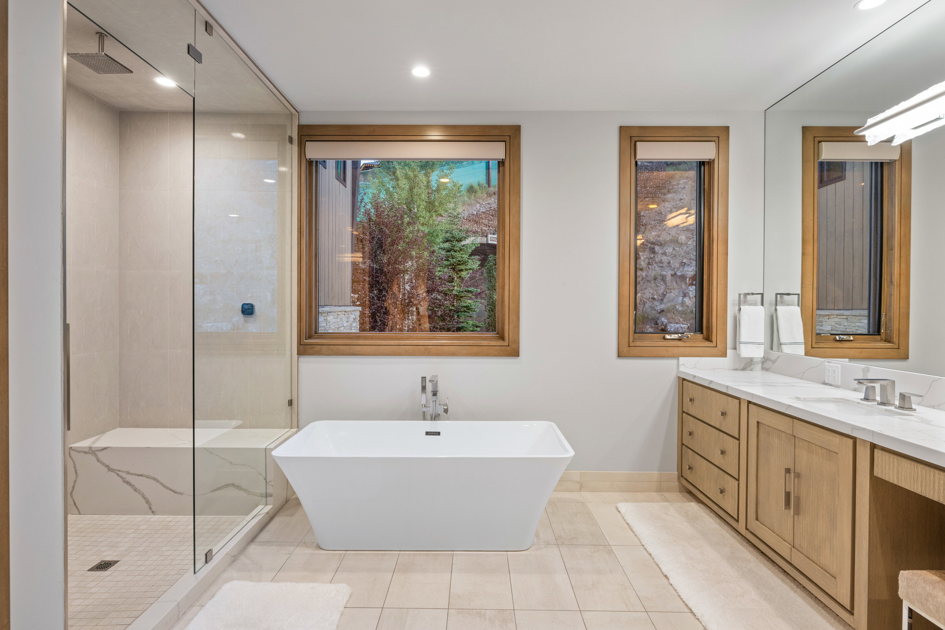 Bathroom featuring a tile shower, a freestanding bath, vanity, light tile patterned floors, and recessed lighting