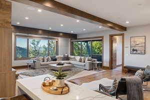 Living area with beamed ceiling, wood-type flooring, and recessed lighting