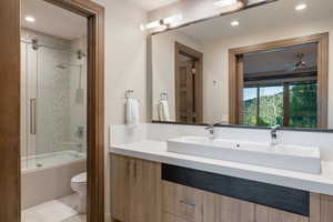 Bathroom featuring vanity, tiled shower / bath combo, and recessed lighting