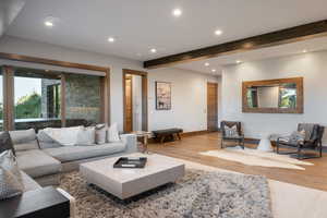 Living area featuring recessed lighting, beam ceiling, healthy amount of natural light, and wood finished floors