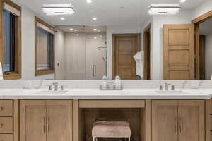 Bathroom featuring a shower stall, double vanity, and recessed lighting