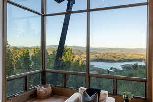 Sunroom featuring a water and mountain view