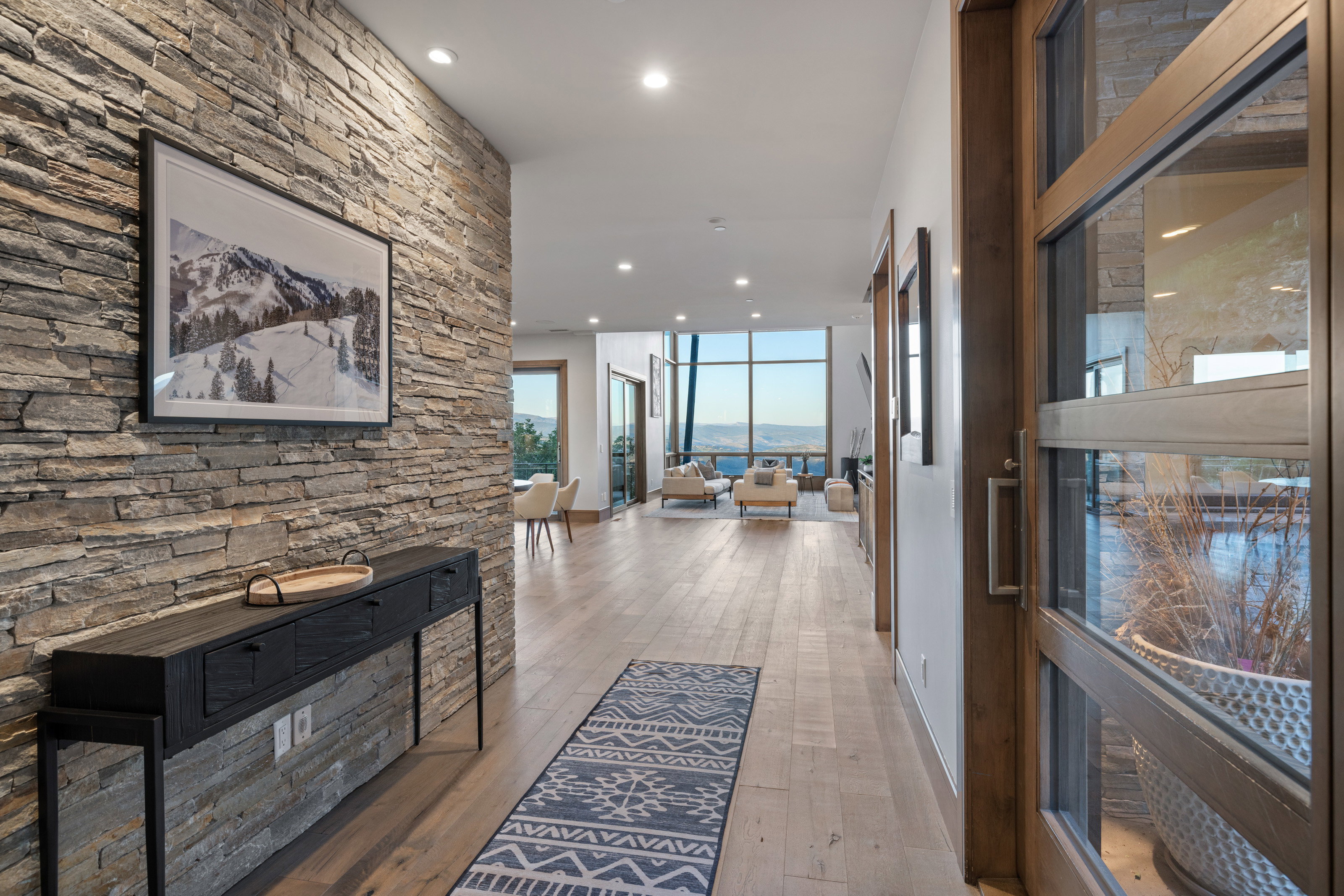 Corridor featuring recessed lighting, light wood-style flooring, and floor to ceiling windows