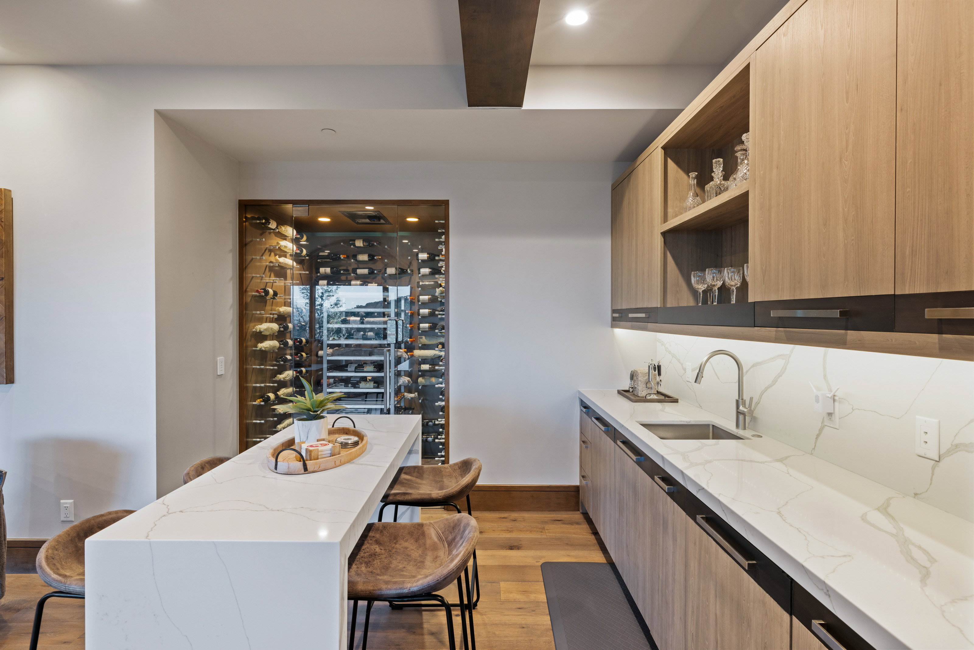 Kitchen with a kitchen breakfast bar, light stone countertops, open shelves, light wood finished floors, and recessed lighting