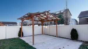Fenced backyard with a patio area, a gazebo, and a residential view