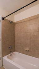 Bathroom featuring washtub / shower combination and a textured ceiling