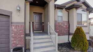 Doorway to property with stucco siding and brick siding