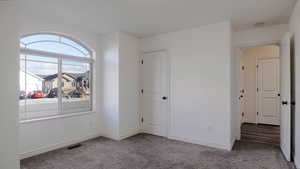 Unfurnished bedroom featuring carpet floors and baseboards
