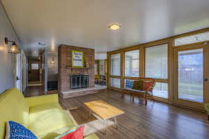 Living area featuring wood finished floors, plenty of natural light, and a fireplace