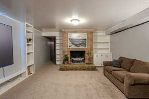 Living area with a fireplace and light carpet