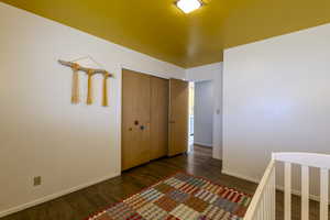 Unfurnished bedroom featuring dark wood-type flooring and a closet