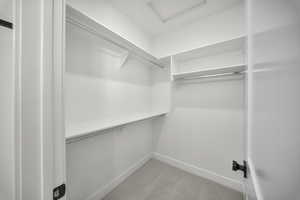 Walk in closet featuring light carpet and attic access