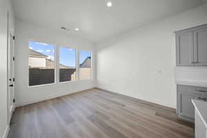 Unfurnished dining area with light wood-type flooring and recessed lighting