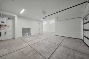 Garage with baseboards and a garage door opener
