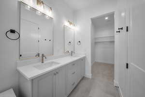 Bathroom with double vanity and a spacious closet