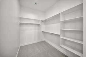 Walk in closet with light carpet
