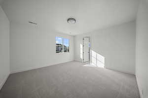 Empty room featuring carpet and baseboards