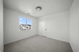 Carpeted empty room with baseboards