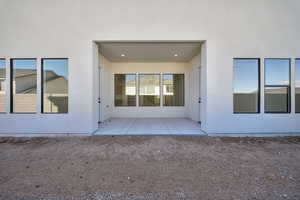Doorway to property with a patio and stucco siding