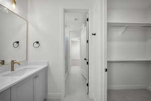 Bathroom featuring a walk in closet and vanity