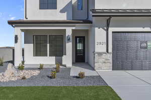 Doorway to property featuring stucco siding and stone siding
