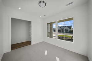 Carpeted empty room with recessed lighting and baseboards
