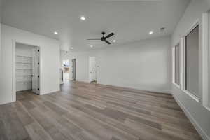 Unfurnished bedroom featuring recessed lighting, a ceiling fan, light wood-style flooring, and a spacious closet
