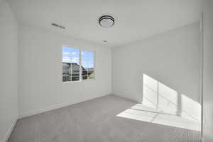 Carpeted spare room with baseboards