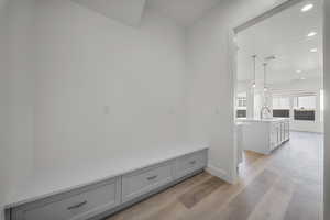 Mudroom featuring light wood-style flooring and recessed lighting