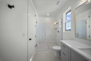 Bathroom featuring a stall shower, vanity, and recessed lighting